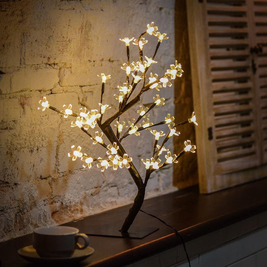 24 LED night light table lamp shaped like a flowering tree with warm white lights on a wooden surface