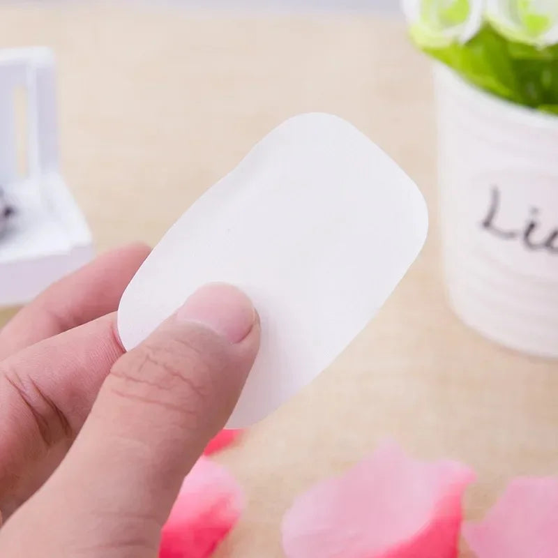 Hand holding a single white sheet from 4 box travel soap paper sheets by Clarify.pk