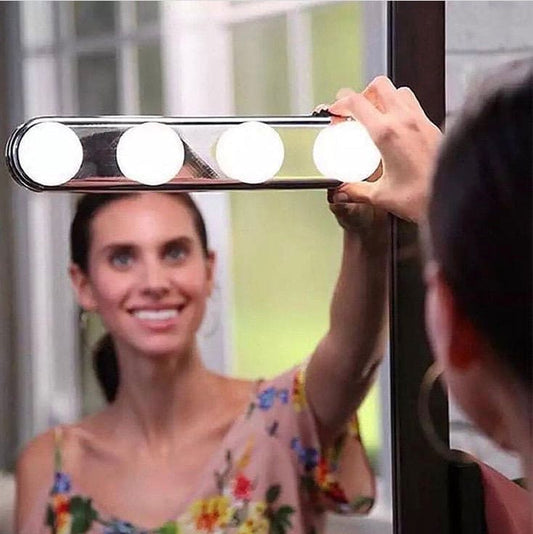 Woman adjusting a 4 bulb makeup mirror light mounted on a mirror for bright makeup application