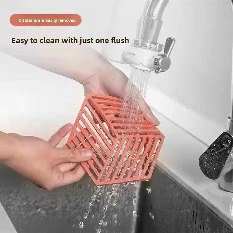 Hands washing a red 4 pieces heat resistant silicone dining mat under running kitchen faucet for easy cleaning