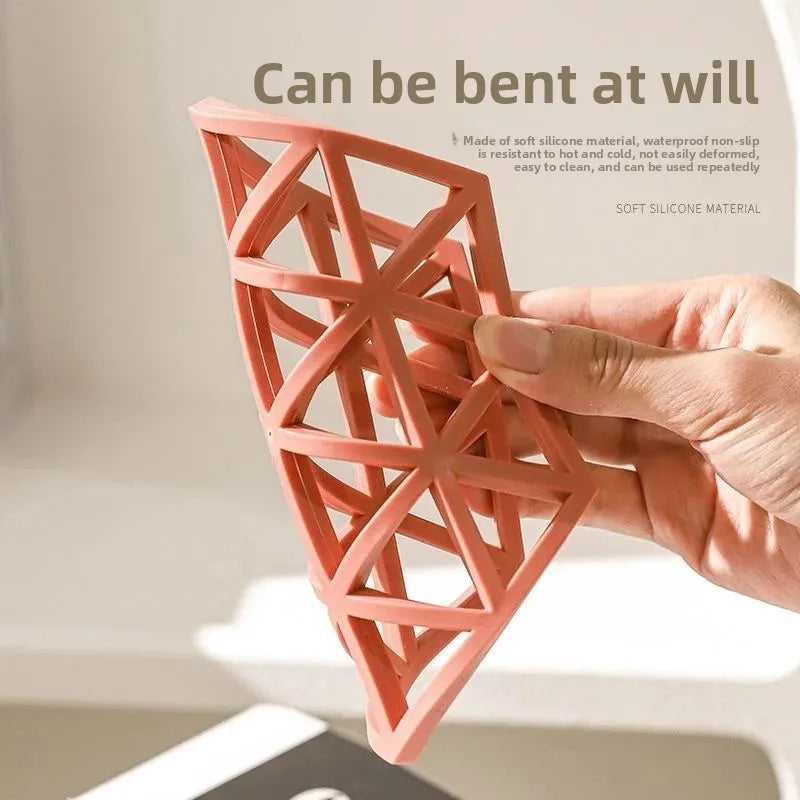 Hand bending a soft 4 pieces heat resistant silicone dining mat showing flexible non-slip design