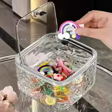 Clear acrylic hair accessories organizer storage box with hinged lid holding colorful hair clips