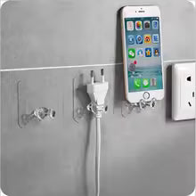 Clear adhesive Wall Storage Hook holding phone and electrical plug on gray wall surface