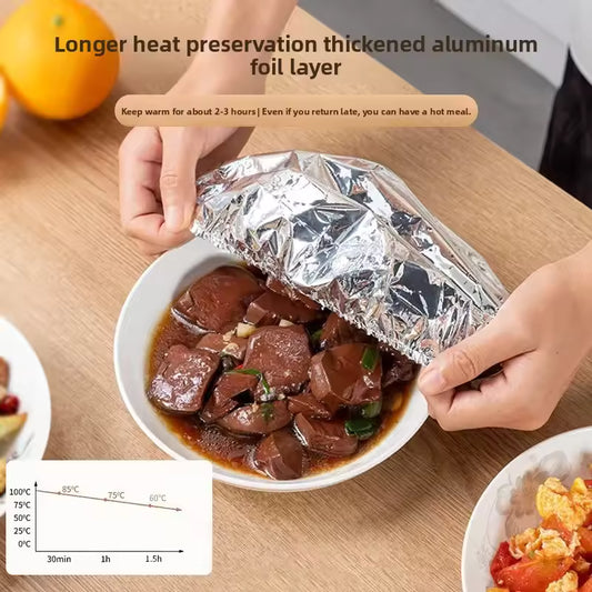 Person covering meal with aluminum foil pack for meal prep to preserve heat on wooden table