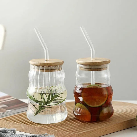 bamboo lid glass mug with straw filled with iced tea and lemon slices on wooden tray