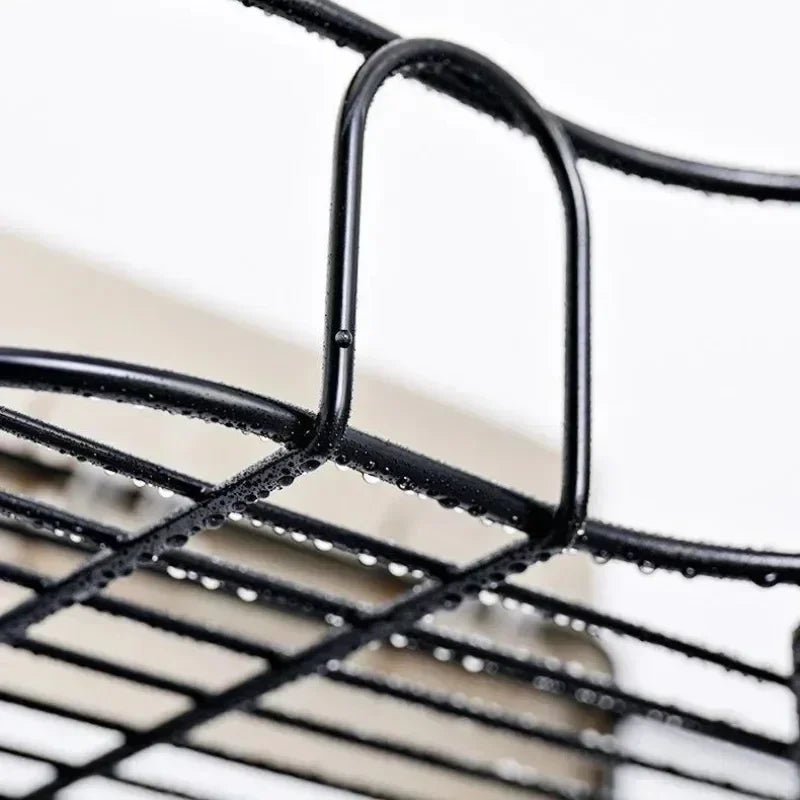 Close-up of black metal bathroom corner shelf wall mounted with water droplets on the surface