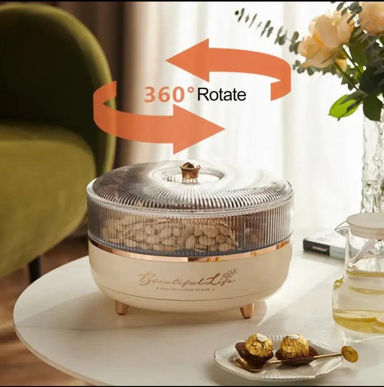 Luxury dry fruit tray with 360 degree rotating transparent lid and golden accents on white table