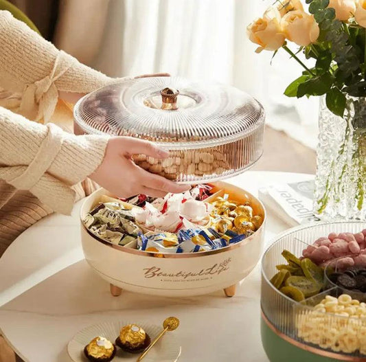 Luxury dry fruit tray with a clear lid filled with assorted snacks on a white table