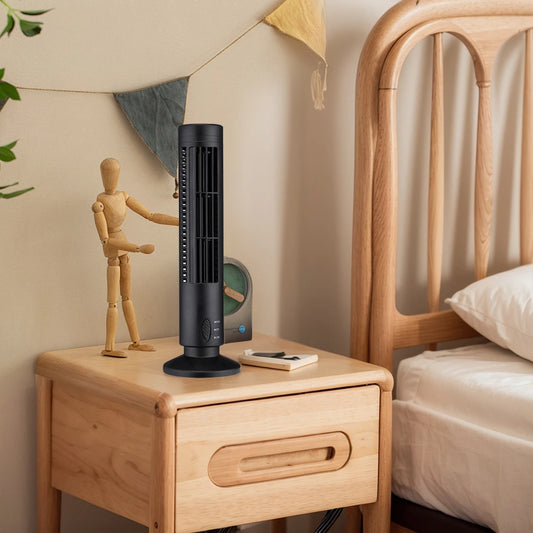Black bladeless desktop tower fan on wooden bedside table next to a wooden mannequin in bedroom