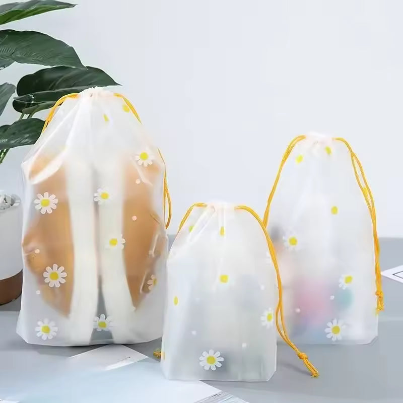 Clarify.pk 4 piece travel storage bags with white floral design and yellow drawstrings for organizing luggage