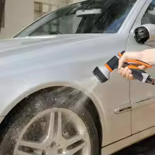 Using 8 pattern water gun to wash silver car tire and side panel with powerful water spray