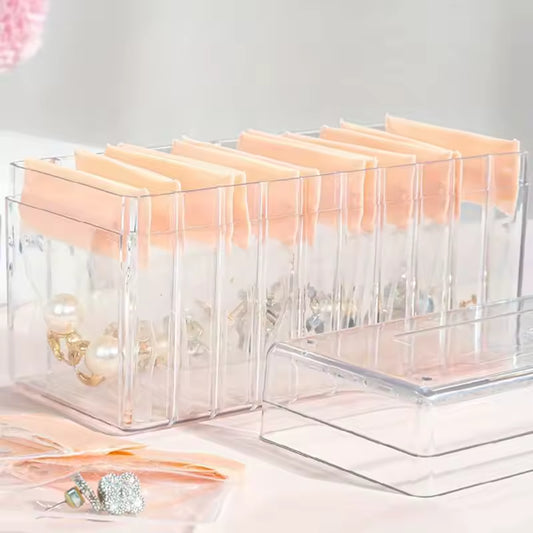 Clear acrylic jewelry organizer with multiple compartments and soft peach cushions for earrings