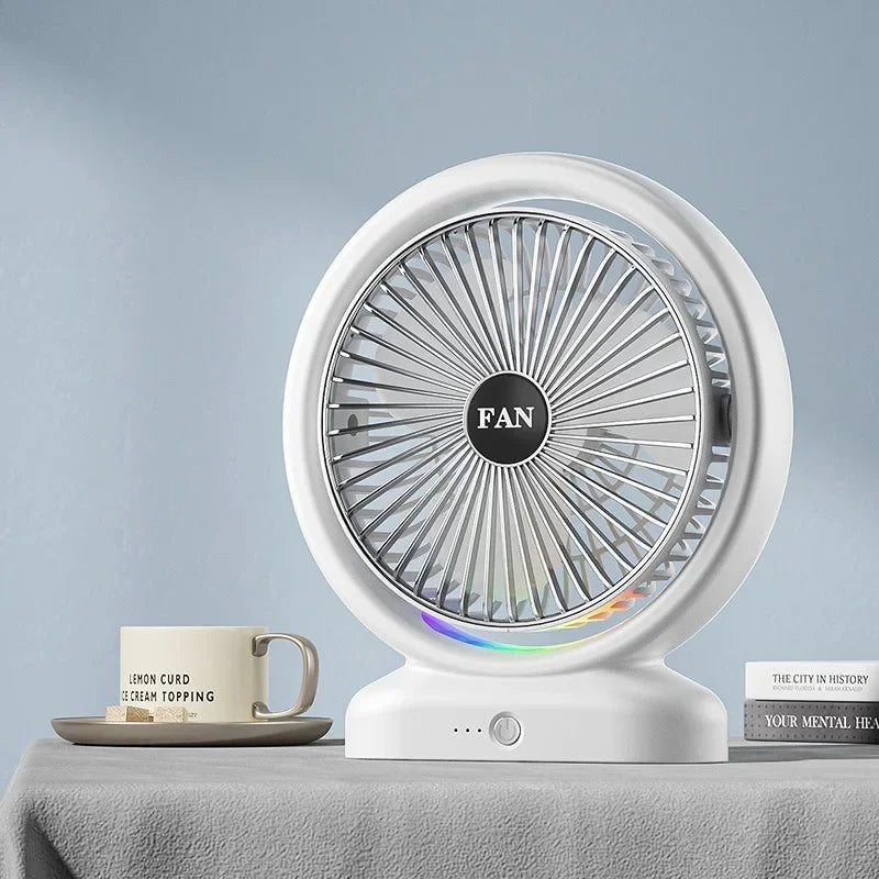 White colorful LED desk fan with circular blades and modern design on a table next to a coffee cup and books