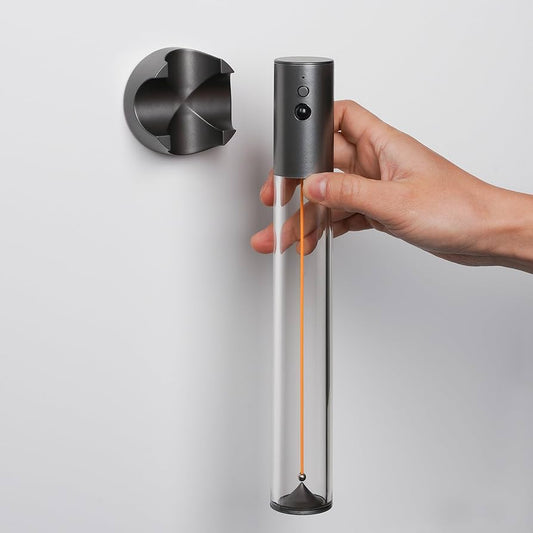 Hand holding a modern cordless LED night light for room with sleek cylindrical design and wall mount