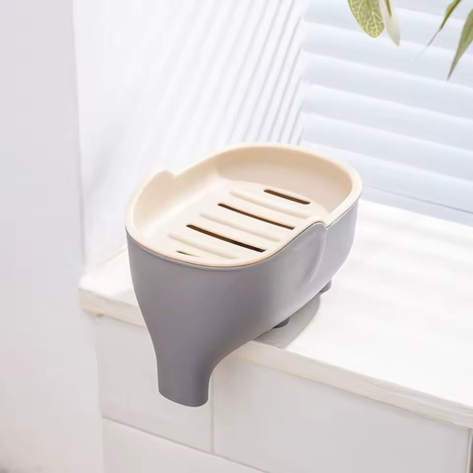 Creative animal soap holder for bathroom in beige and gray mounted on white tiled wall near window