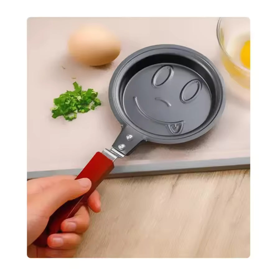 Creative cartoon mini omelette pan with smiling face design and red handle by Clarify.pk