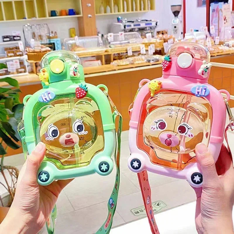 Cute bear water cup for kids in green and pink with bear face design and carry straps by Clarify.pk
