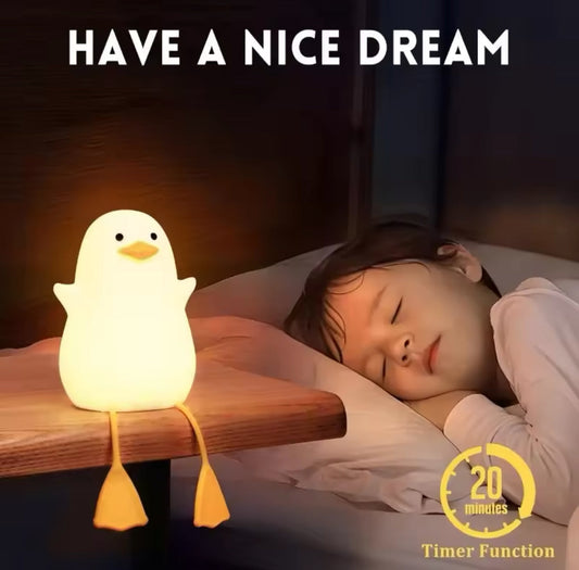 Cute duck night lamp glowing softly on bedside table next to sleeping child with timer function