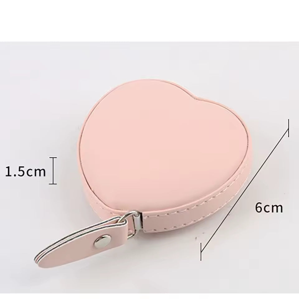 Cute heart shaped tape measure in pink with compact design and a snap button strap