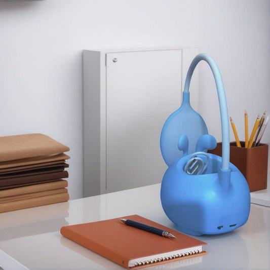 Blue cute rabbit desk lamp with flexible neck on a white desk near notebooks and pencils