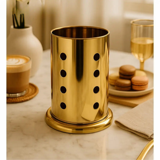 Gold metallic cutlery holder for countertop with perforated design on marble surface