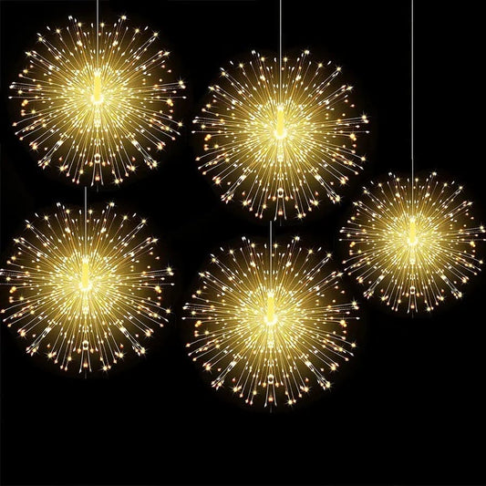 Five glowing firework string lights battery operated with warm yellow LED bulbs hanging on black background