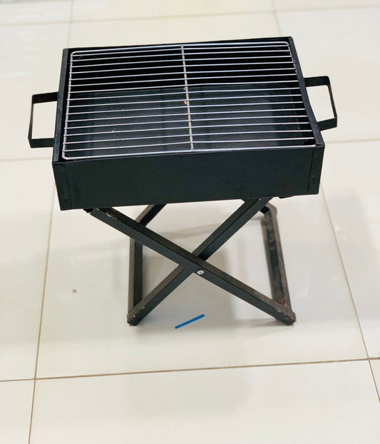 Black portable bbq grill for home use with foldable legs and metal cooking grate