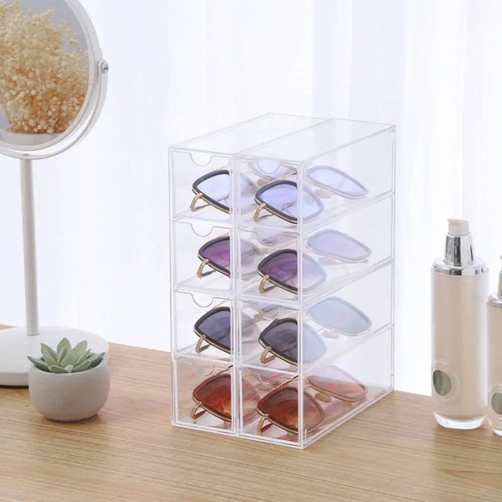 Clear acrylic sunglasses storage box with multiple compartments holding various sunglasses