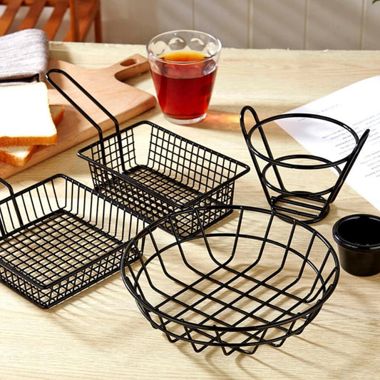 Set of black metal french fries basket in various shapes for serving snacks on wooden table
