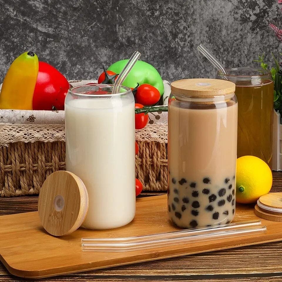 Bamboo lid iced coffee mug with glass straw filled with bubble tea on wooden board