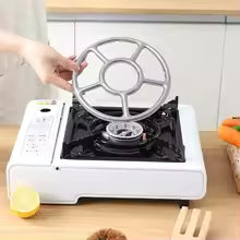 Clarify.pk gas stove stabilizer bracket being placed on a white single burner gas stove