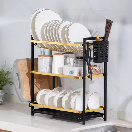 Clarify.pk black and gold metal dish drying rack with multiple tiers holding plates, bowls, and utensils