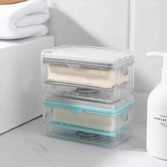 Transparent soap holders stacked on a bathroom counter next to a white hands-free soap dispenser