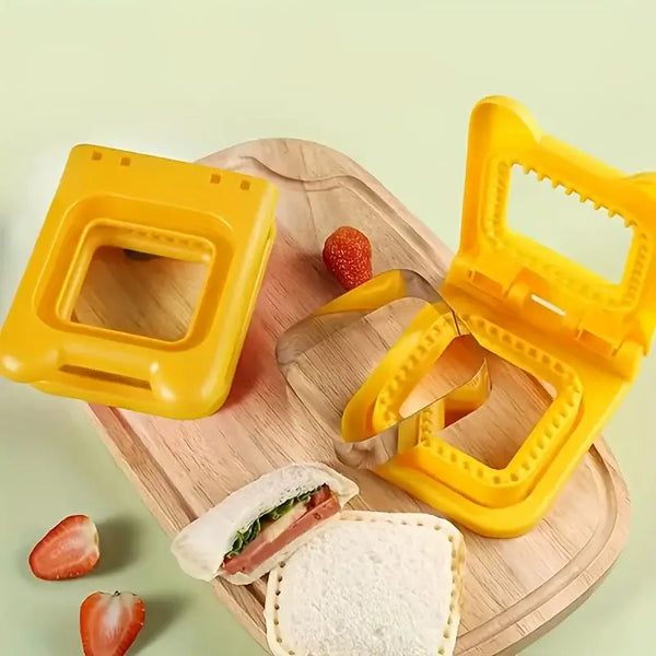 Yellow sandwich cutter and sealer set on wooden board with prepared sealed triangle sandwich and strawberries