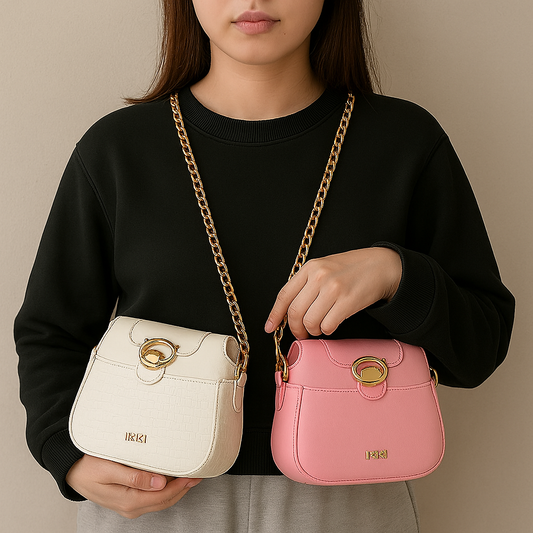 Woman holding two stylish small handbags with gold chain straps in white and pink colors