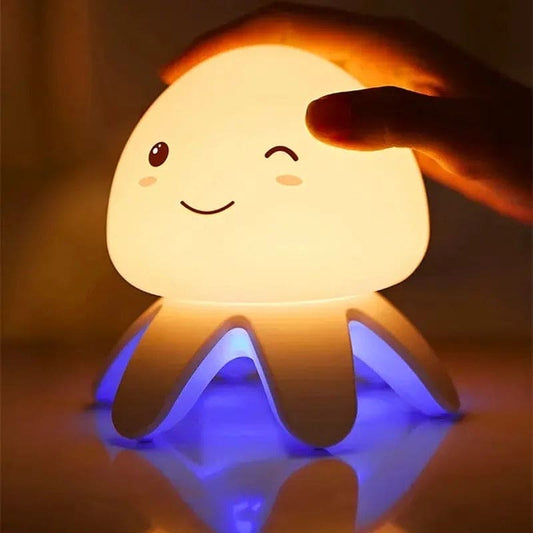 Cute octopus-shaped jellyfish night light glowing with blue and warm white light in a dark room
