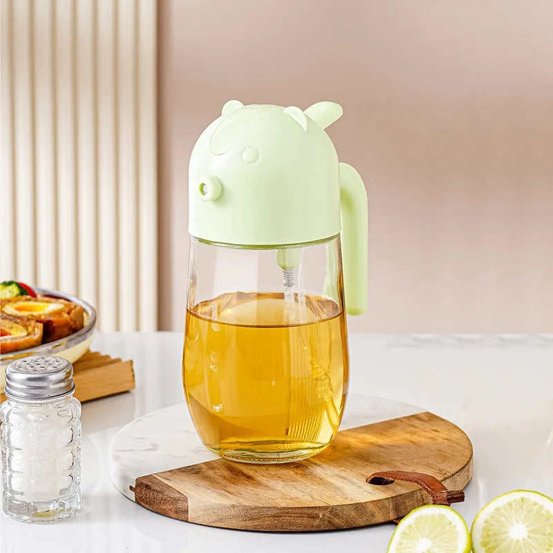 Clarify.pk 2 in 1 olive oil dispenser with transparent body and light green animal-shaped top on wooden board