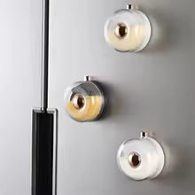 Set of three clear kitchen magnetic spice jars mounted on a gray surface for easy herb storage