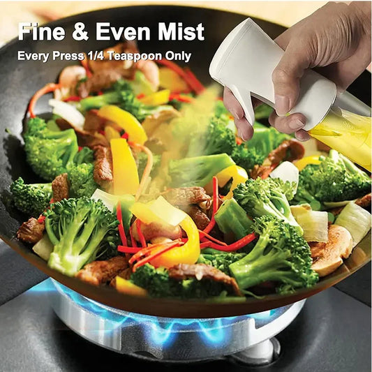 Hand spraying oil from a kitchen oil spray bottle onto stir-fry vegetables cooking on a gas stove