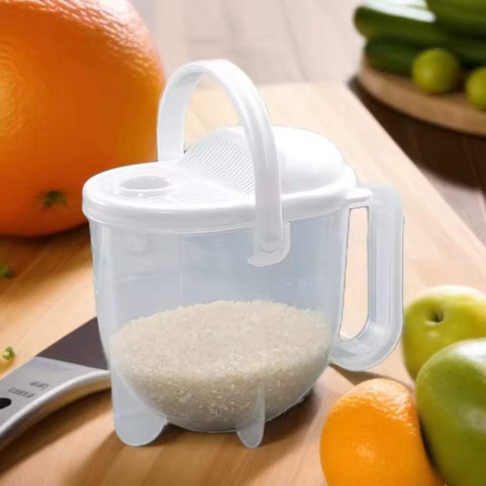 Clear plastic rice strainer with handle and lid filled with rice on a wooden cutting board
