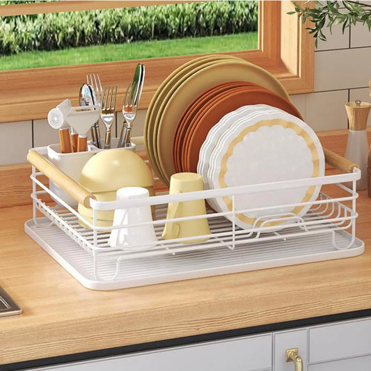 White iron frame kitchen storage rack with wooden handles holding plates and utensils on countertop