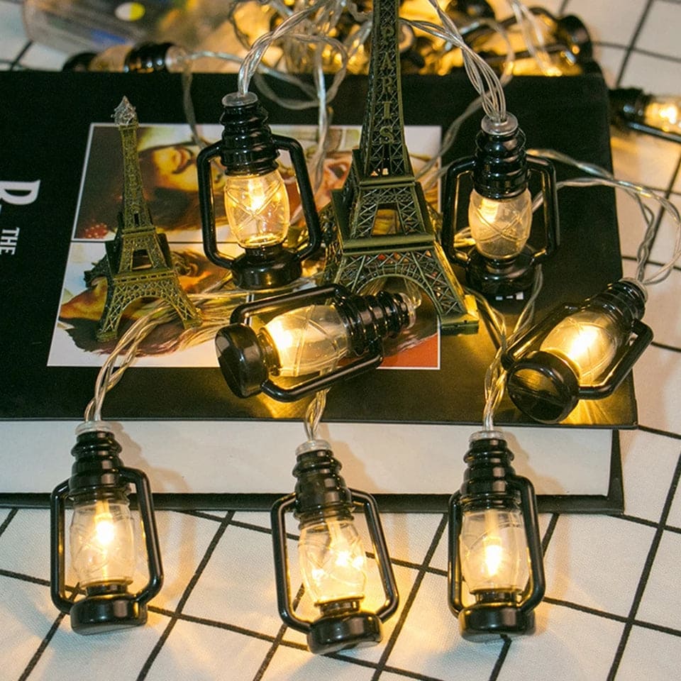 Lantern string lights set with warm glowing bulbs displayed around Eiffel Tower models