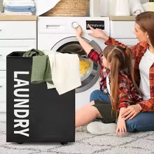 Clarify.pk black laundry storage basket with white text holding clothes next to washing machine