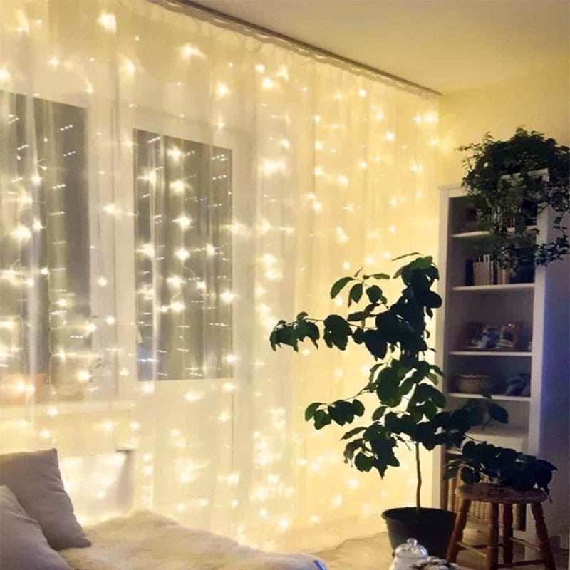Warm white LED curtain lights for home decor hanging on window with cozy indoor plants and furniture
