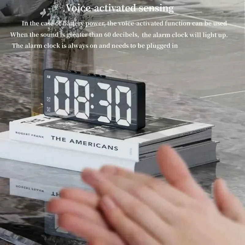 LED digital alarm clock with large display and voice-activated feature on a table