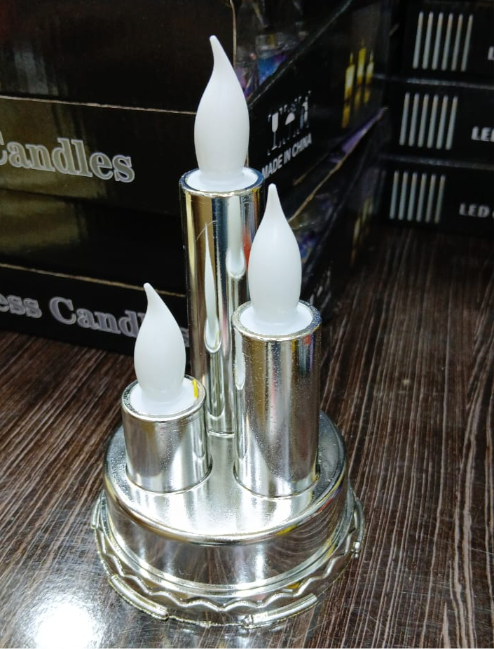 Silver LED flameless candle for home decor with three white flame-shaped lights on a round base