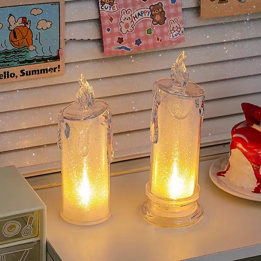 Two clear glass LED pillar candle light with realistic flame effect on white surface