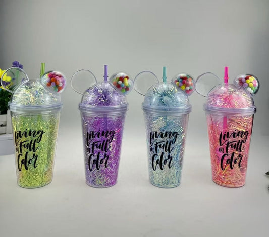 Colorful water bottles with Mickey Mouse ears and straws filled with decorative tinsel and candy