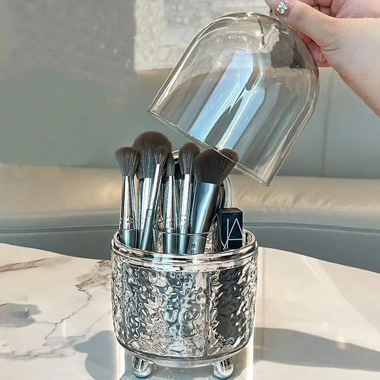 Luxury makeup brush organizer made of hammered silver with clear dome lid on marble table