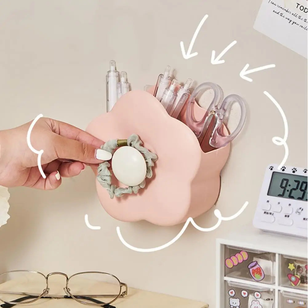 Clarify.pk pink flower-shaped makeup brush organizer box mounted on wall holding scissors and pens